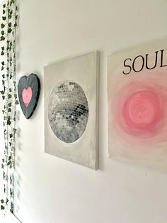 two paintings are hanging on the wall next to each other, one has a heart