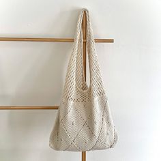 a white bag hanging on a wooden rack