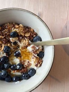 a bowl filled with granola, blueberries and yogurt