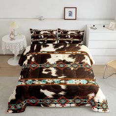 a bed with a cow print comforter and pillows