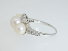 "This exquisite little treasure features 3 luscious white pearls surrounded by 14 small old European and old mine cut diamonds . Set in 18K white gold. The ring is a size 6.75. Setting measures approx. 1/2\" tall. This ring is in excellent pre-owned vintage condition. Total weight is approx. 4.8 grams. (T8 * MJP038283) Please review all photos before purchasing and feel free to ask questions about the item :) For more information you can call us at 360-657-5276. We are sorry but we do NOT offer Elegant White Gold Pearl Ring With Rose Cut Diamonds, Heirloom White Gold Pearl Ring With Rose Cut Diamonds, Heirloom White Diamond Pearl Ring, Heirloom White Pearl Ring With Rose Cut Diamonds, Classic Pearl Ring With Diamonds For Anniversary, Classic Pearl Ring With Rose Cut Diamonds For Anniversary, Antique White Gold Pearl Ring For Wedding, Classic Pearl Ring With Single Cut Diamonds For Wedding, Classic White Pearl Ring With Rose Cut Diamonds