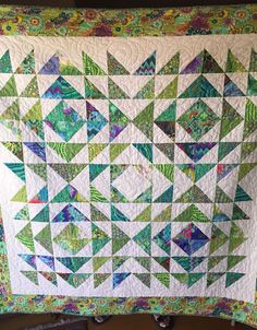 a green and white quilt with triangles on it