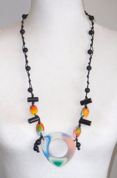 This necklace is part of the retired Tropicalia line and is called Lila. This necklace features 5 tropical colored beads on a strand of black beads hand knotted on a black cord. The length is 32".  The first United Nations Conference to address environmental degradation was held in Stockholm in 1972. Already at that time the designer Carlos Sobral was working with resin and creating new techniques and alternative products to reuse all the raw material he consumed in the production of his collect Environmental Degradation, Artisan Jewelry Necklaces, Handcrafted Artisan Jewelry, Earring Cards, United Nations, Raw Material, Fabric Jewelry, Jewelry Pouch, Black Beads