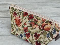 a small floral purse sitting on top of a wooden table