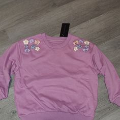 Lilac Purple Sweatshirt. Brand New With Tag. Size 5t. Purple Floral Embroidery Top For Fall, Cute Floral Embroidery Crew Neck Tops, Cute Floral Embroidered Long Sleeve Tops, Cute Floral Embroidery Fall Tops, Purple Floral Embroidered Top For Fall, Purple Crew Neck Top With Floral Embroidery, Casual Pink Sweatshirt With Floral Embroidery, Trendy Purple Spring Sweatshirt, Pink Cotton Tops With Floral Applique