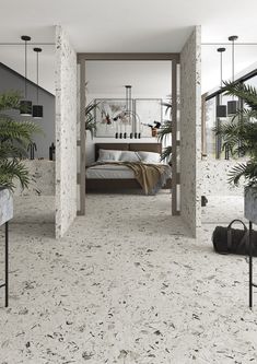 a bedroom with white walls and flooring next to plants