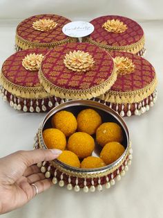 a hand is reaching for some food in a metal bowl on a white tablecloth