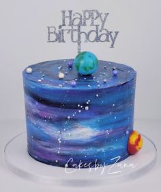 a birthday cake with blue and purple frosting, stars and planets on the top