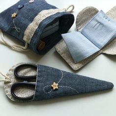 three pairs of scissors are sitting next to each other in denim pouches with buttons on them