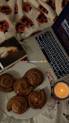 there is a plate of cinnamon rolls next to a laptop