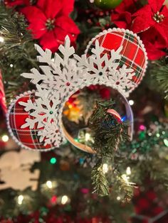 a christmas tree decorated with red and green ornaments, poinsettis and lights