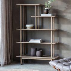 a living room with a chair and shelves on the wall in front of a window