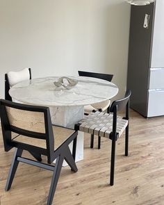 a marble table and chairs in a room with wood floors, white walls and wooden flooring