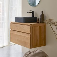 a bathroom with a sink and mirror on the wall next to a vase filled with flowers