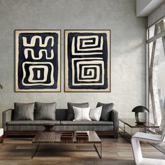 a living room with two paintings on the wall and couches in front of it