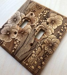 a decorative wooden switch plate with flowers on it