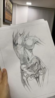 a person holding up a drawing in their hand