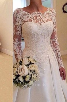 the bride is posing in her wedding dress