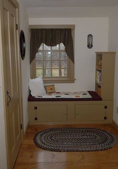 a room with a window, bookcases and a rug on the floor