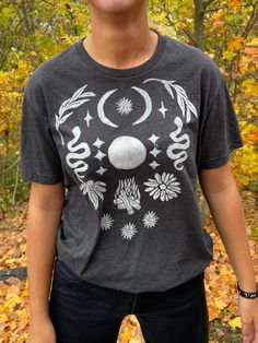 A secondhand T-Shirt with a block-printed design! This Full Moon Design was created with ceremony in mind - wear this shirt near the full moon or when you need some extra full moon energy in your daily life (or if you just want to look very cute with very little effort). This design is offered in other sizes and colors - please see my Etsy page for more offerings! My mission is to bring sacred ceremony into daily life. By curating secondhand clothes and adding symbolism with intention, I hope to spread some love of nature, the Divine, and simple beauty back into all our lives. Each piece I offer was thrifted and chosen with care, lovingly block-printed with hand-carved stamps, and shared with you in community.  My process usually goes a little something like this: Inspiration from nature, Mystical Cotton Crew Neck T-shirt, Festival T-shirt With Screen Print And Relaxed Fit, Bohemian Short Sleeve T-shirt With Sun And Moon Design, Bohemian Cotton T-shirt With Sun And Moon Design, Mystical Short Sleeve Top With Graphic Print, Mystical Crew Neck Cotton T-shirt, Mystical Graphic Print Short Sleeve Top, Mystical Style Cotton T-shirt With Crew Neck, Mystical Graphic Print Crew Neck Top