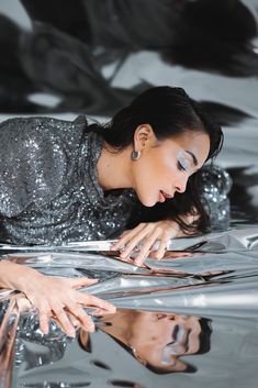 a woman laying on top of a shiny surface