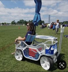 a woman sitting on top of a cart in the grass