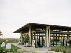 a large building with lots of windows on top of it's roof and grass in front of it