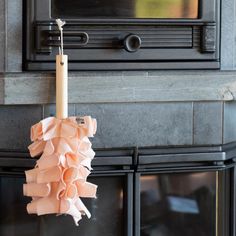 a candle hanging from the side of a fireplace with ruffles on it's mantle