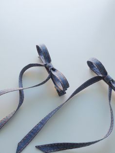 two blue ribbons tied together on a white surface