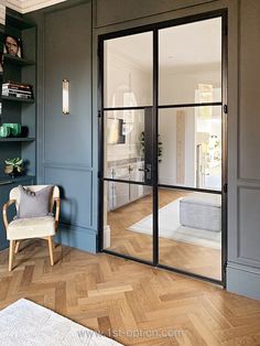 a living room filled with furniture and lots of glass doors that lead into the kitchen