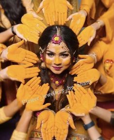 a woman in yellow is surrounded by her hands