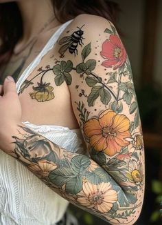 a woman with tattoos and flowers on her arm