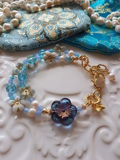 Delightful selection of Springtime soft blue & white tones in in this Bohemian Beaded bracelet. This bracelet has been made with love and I have used assorted selection of super cute Czech glass beads, including these super cute Czech Pansy flowers, some pearls, Aqua blue Agate Rondelles and the most gorgeous Blue Frangipani focal bead. To add to the theme of Springtime I have added a super cute Gold Vermeil Bee charm as well. I have also used pretty gold  CZ clasp and included a extender chain Bohemian Light Blue Flower Jewelry, Handmade Light Blue Beaded Bracelets, Bohemian Light Blue Beaded Bracelets As Gift, Bohemian Light Blue Bracelets For Jewelry Making, Blue Unique Beaded Bracelets, Blue Bracelets With Unique Round Beads, Light Blue Beaded Flower Jewelry, Blue Flower Shaped Beaded Bracelet For Gift, Blue Bohemian Crystal Bracelet With Round Beads