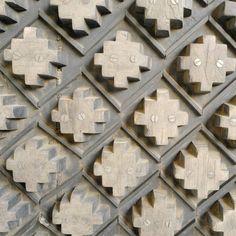 an intricately designed metal surface with crosses on it's sides and holes in the middle