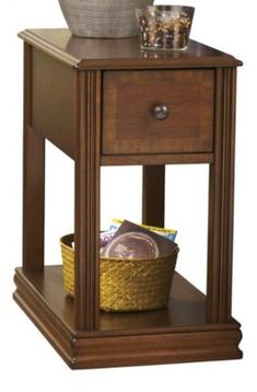 a small wooden table with a basket and bowl on it's shelf next to the end table