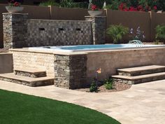 an outdoor hot tub in the middle of a patio with steps leading up to it