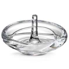 a clear glass bowl with a small metal object in it's center and water running down the side