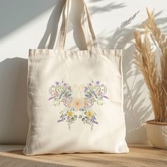 a tote bag sitting on top of a table next to a potted plant