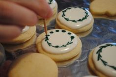 someone is decorating decorated cookies with green and white icing