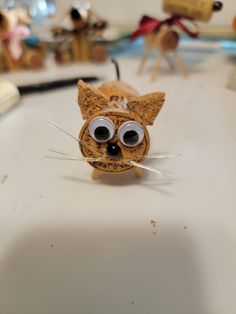 a cat made out of cork with googly eyes