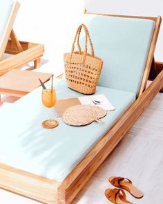 a wicker bag sitting on top of a chaise lounge next to a pair of flip flops