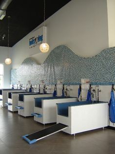 a row of blue and white sinks in a room with tiled walls on the wall