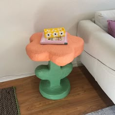 a small table with a book on it in the middle of a room next to a couch