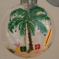 a glass ornament with a palm tree and surfboards on it