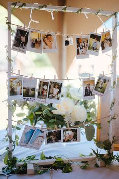 a table topped with pictures and flowers on top of a white cloth covered tablecloth