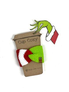 the grinch hat and green knitted hair clip are sitting on top of a cardboard package