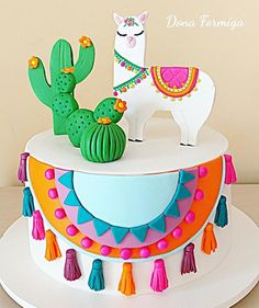 a decorated cake with a llama and cactus on top