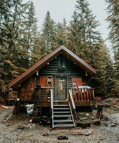 there is a cabin in the woods with stairs leading up to it's door