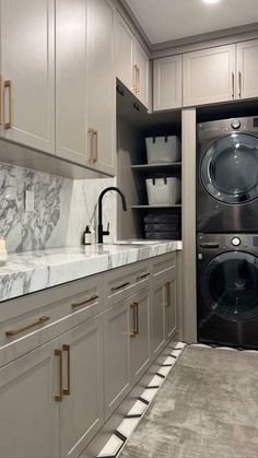 a washer and dryer in a room with marble counter tops on the floor