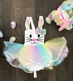 an easter bunny tutule and headband on a wooden floor with other decorations